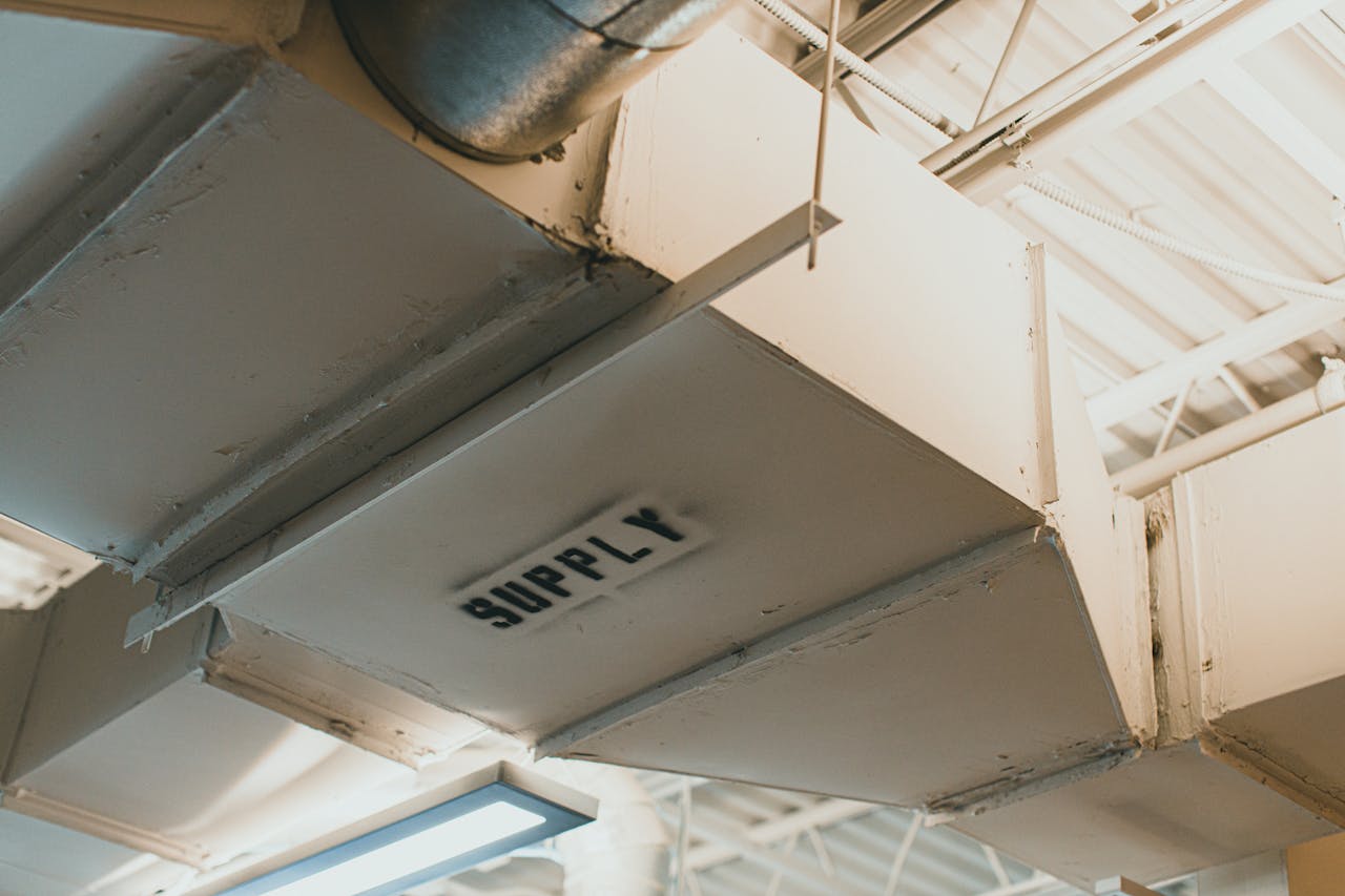 Close-up view of an air duct labeled 'SUPPLY' in an industrial setting.